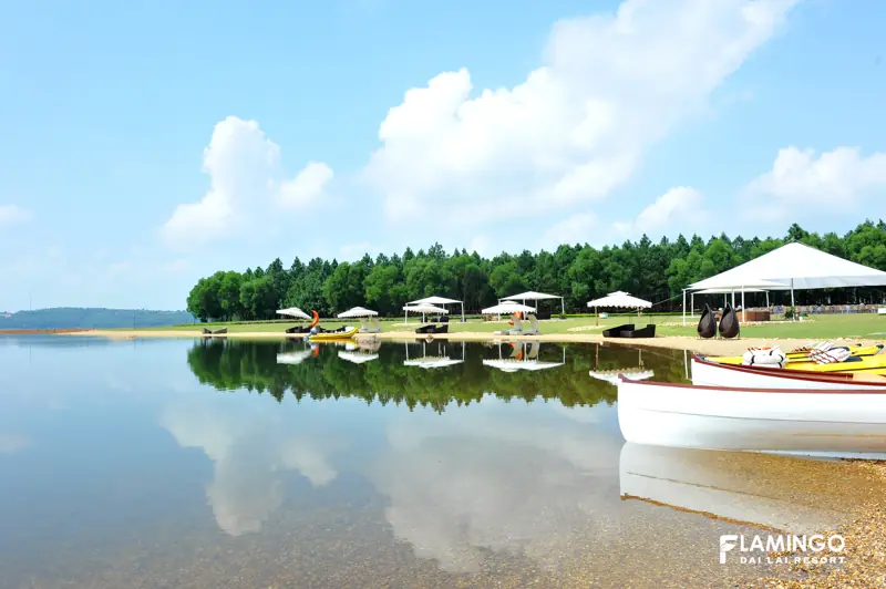 Thuyền gỗ trắng và kayak trên bãi cát Beach Club, mặt hồ Đại Lải phẳng lặng phản chiếu mây