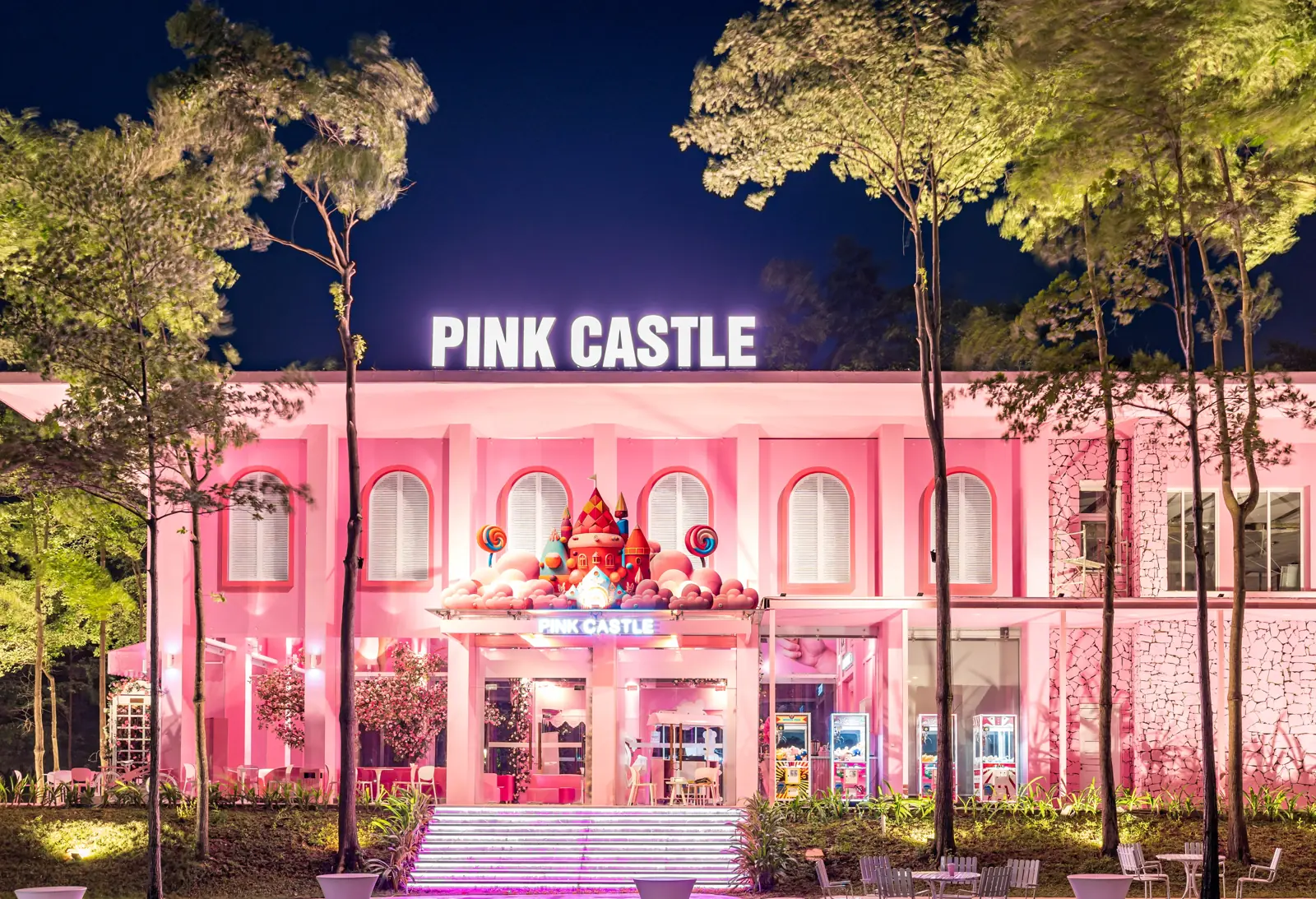 Mặt tiền Pink Castle màu hồng sáng đèn buổi tối ở Flamingo Đại Lải, chữ PINK CASTLE trên mái