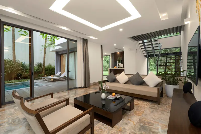 Phòng khách một biệt thự 2 phòng ngủ ở Flamingo Đại Lải, cửa kính mở ra bể bơi và vườn