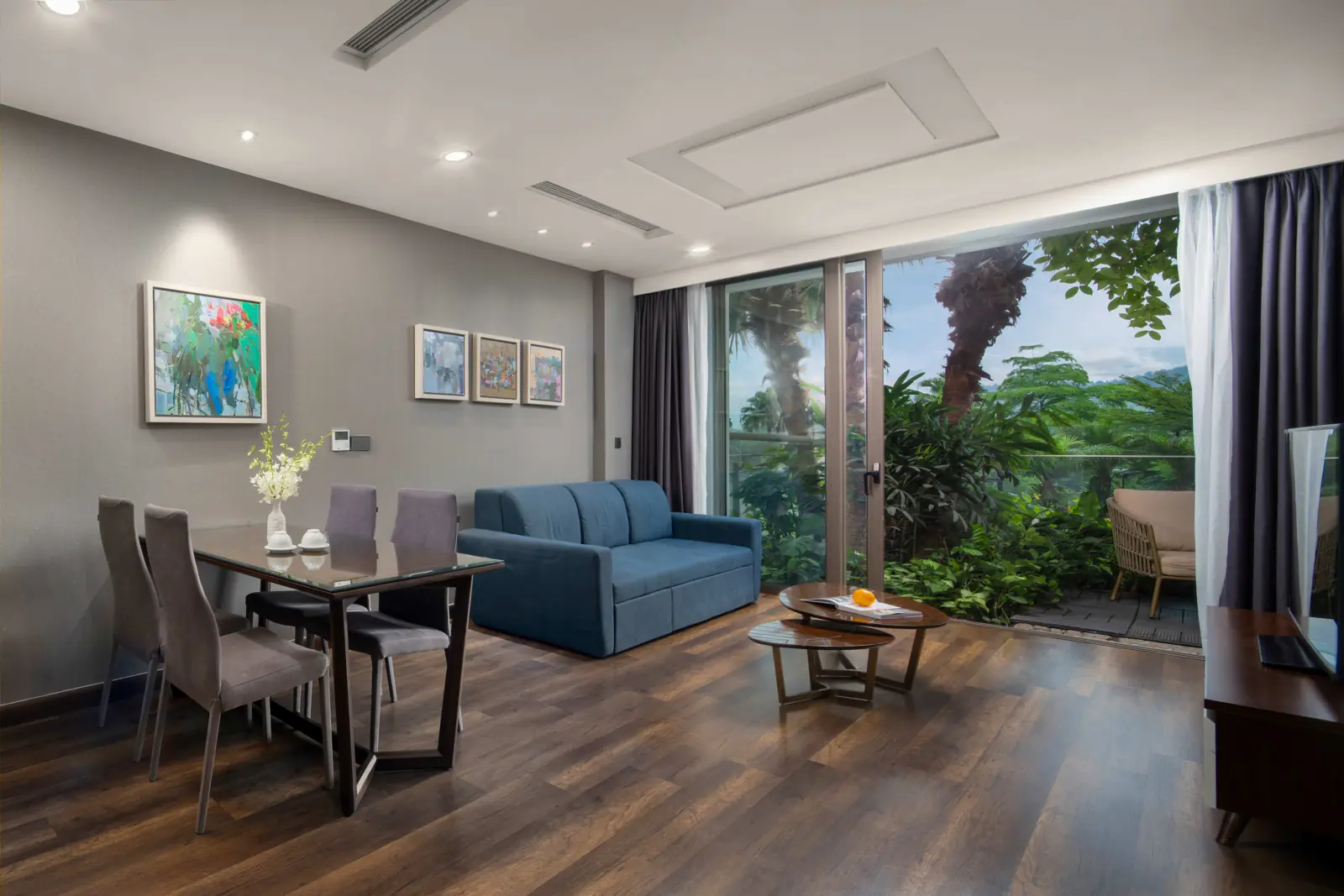 Phòng khách căn Premier Sky Residence 1 phòng ngủ ở tòa Forest in the Sky, cửa kính mở ra ban công phủ cây xanh