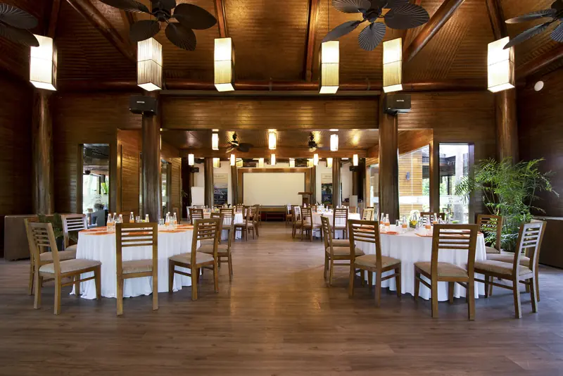 Phòng tiệc Charm Palace lát sàn gỗ, mái gỗ cao, bàn tròn khăn trắng và ghế gỗ