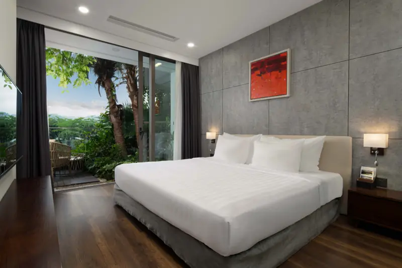 Phòng ngủ Premier Sky Residence: giường King, cửa kính mở ra ban công cây xanh